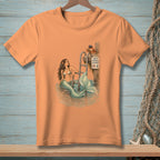 An orange crewneck t-shirt featuring a retro illustration of a mermaid in the water.