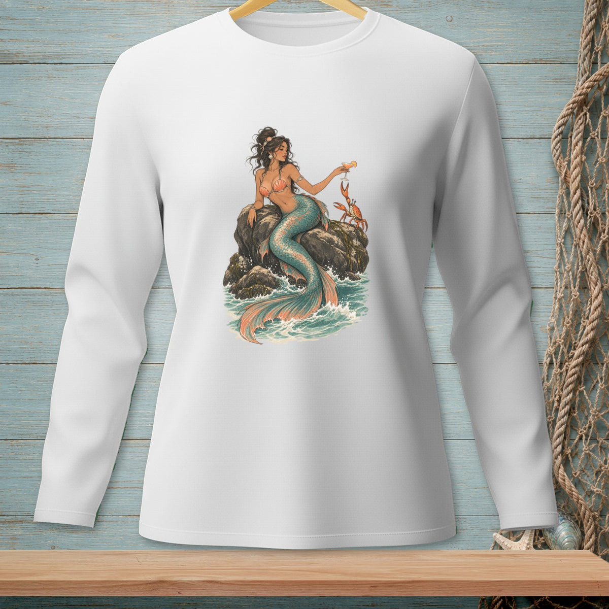 Long-sleeved white shirt with a mermaid sitting on rocks, holding a drink, with two crabs.