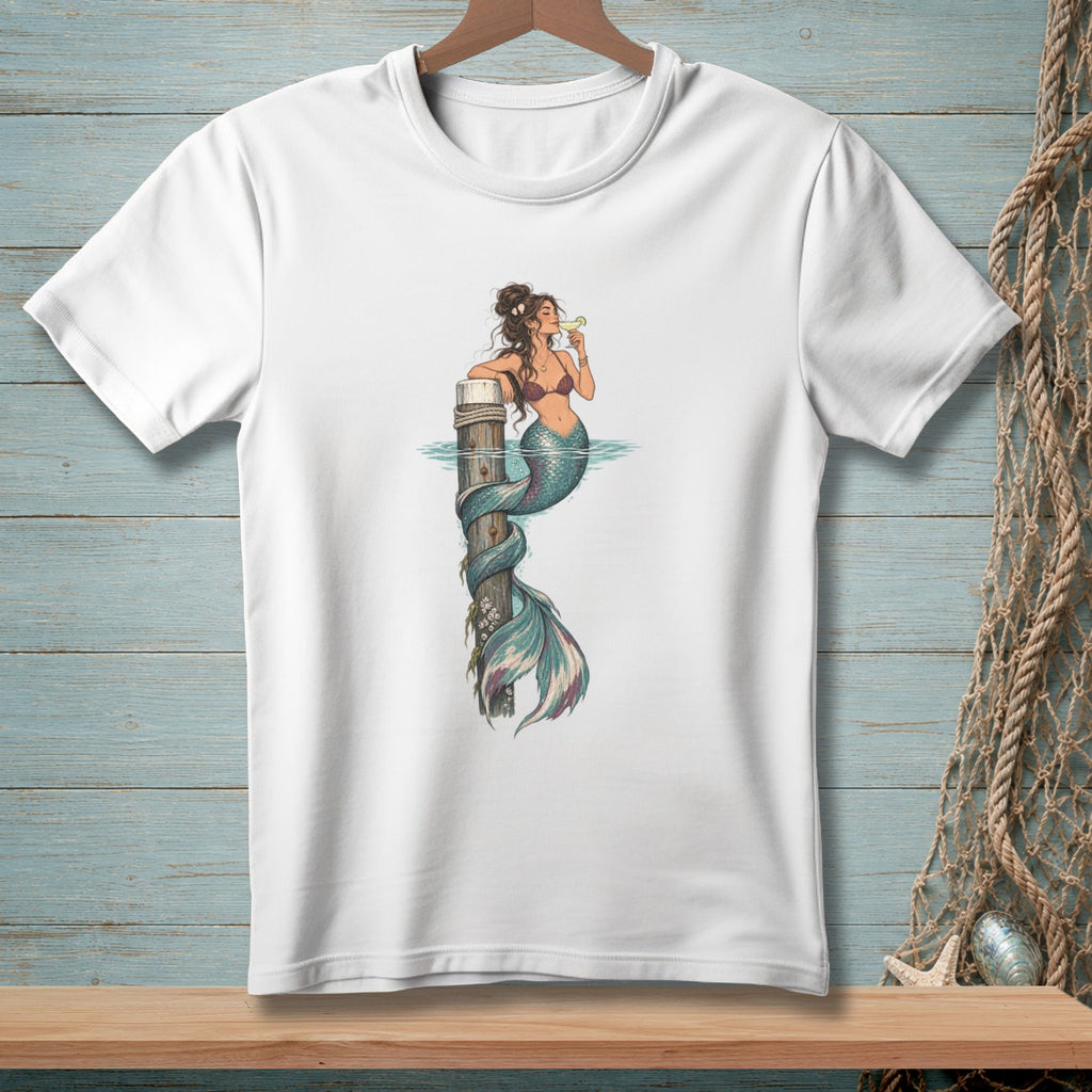 White t-shirt with illustration of a mermaid drinking from a glass while sitting on a post.