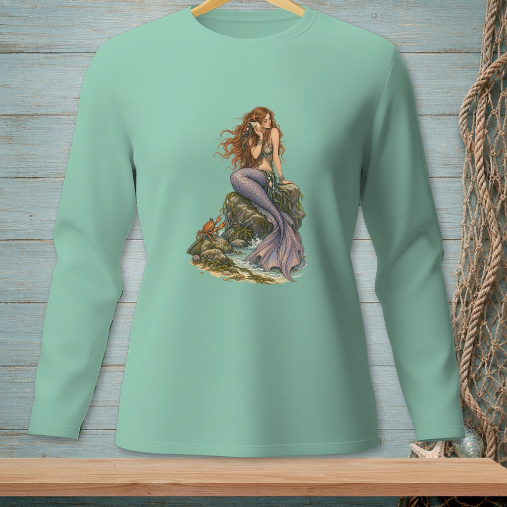 Mint long-sleeve shirt with a graphic of a mermaid sitting on rocks by the sea.