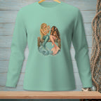 Two mermaids sitting on a wooden pier, one looking in a mirror.