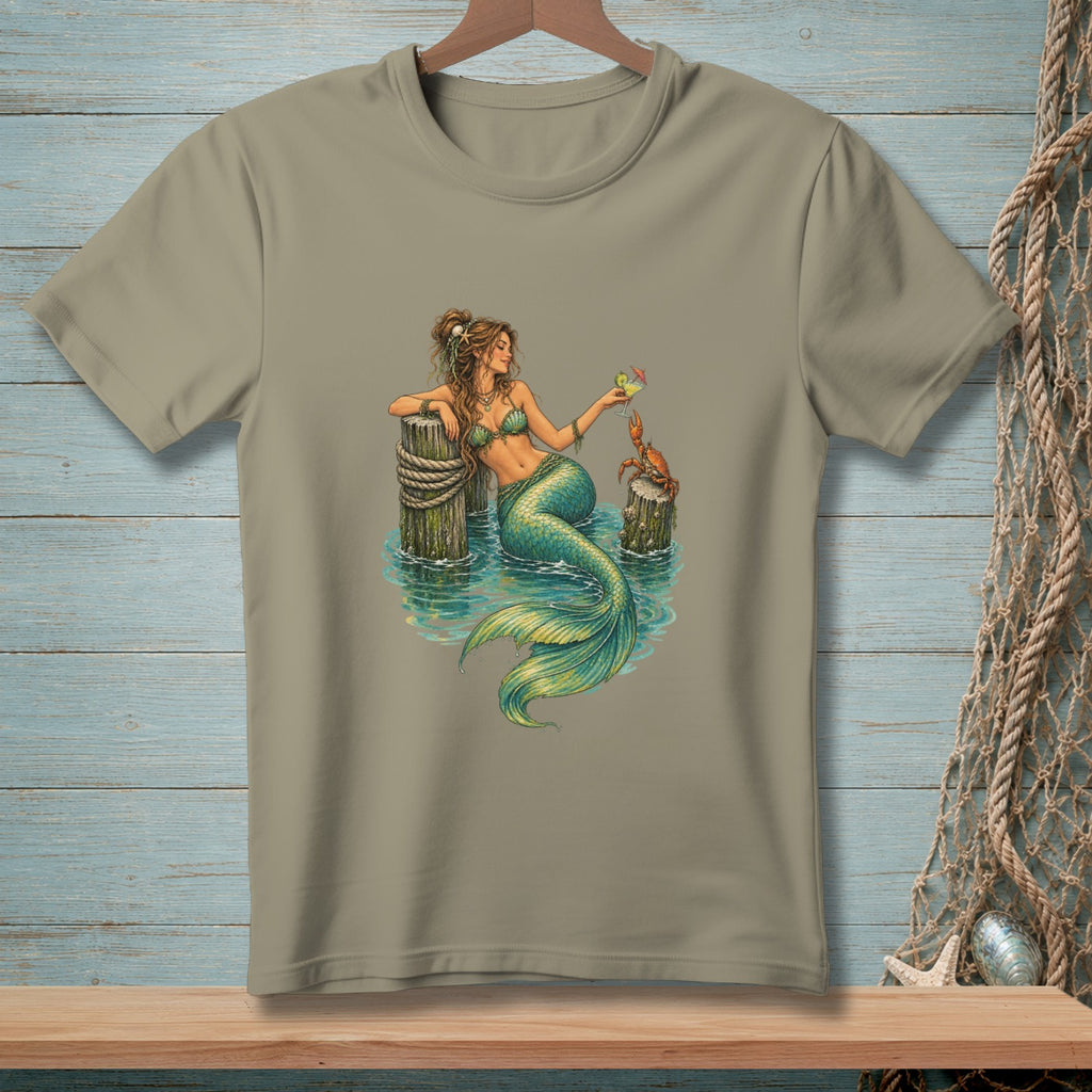 Mermaid holding a drink with a crab on a dock.