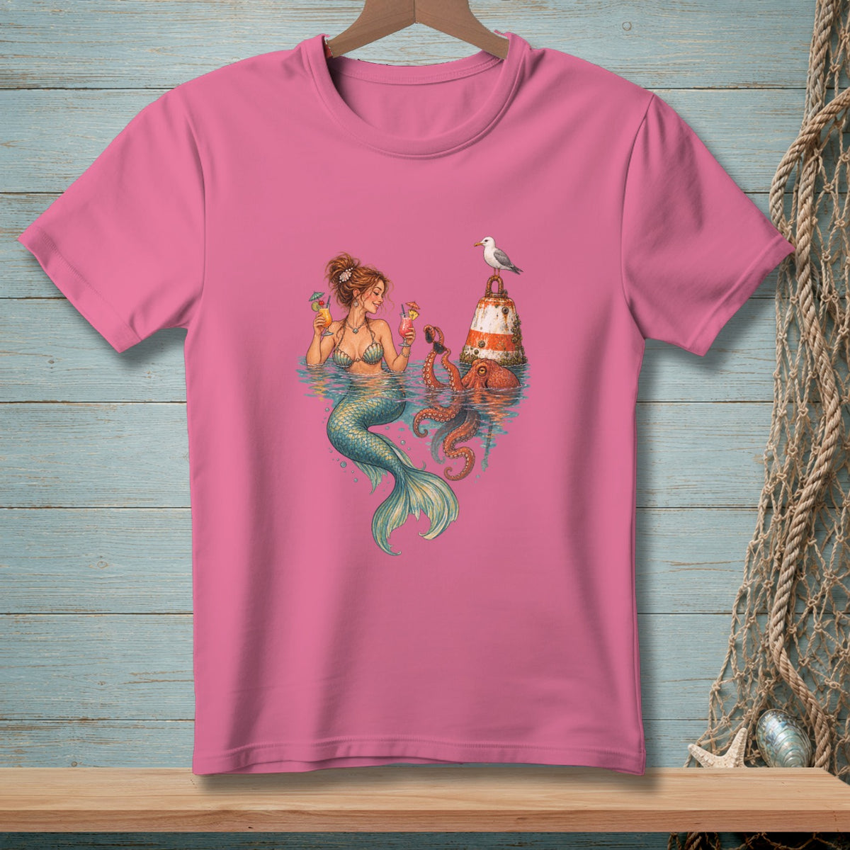 Mermaid with cocktails, octopus, buoy, and seagull on a pink t-shirt.