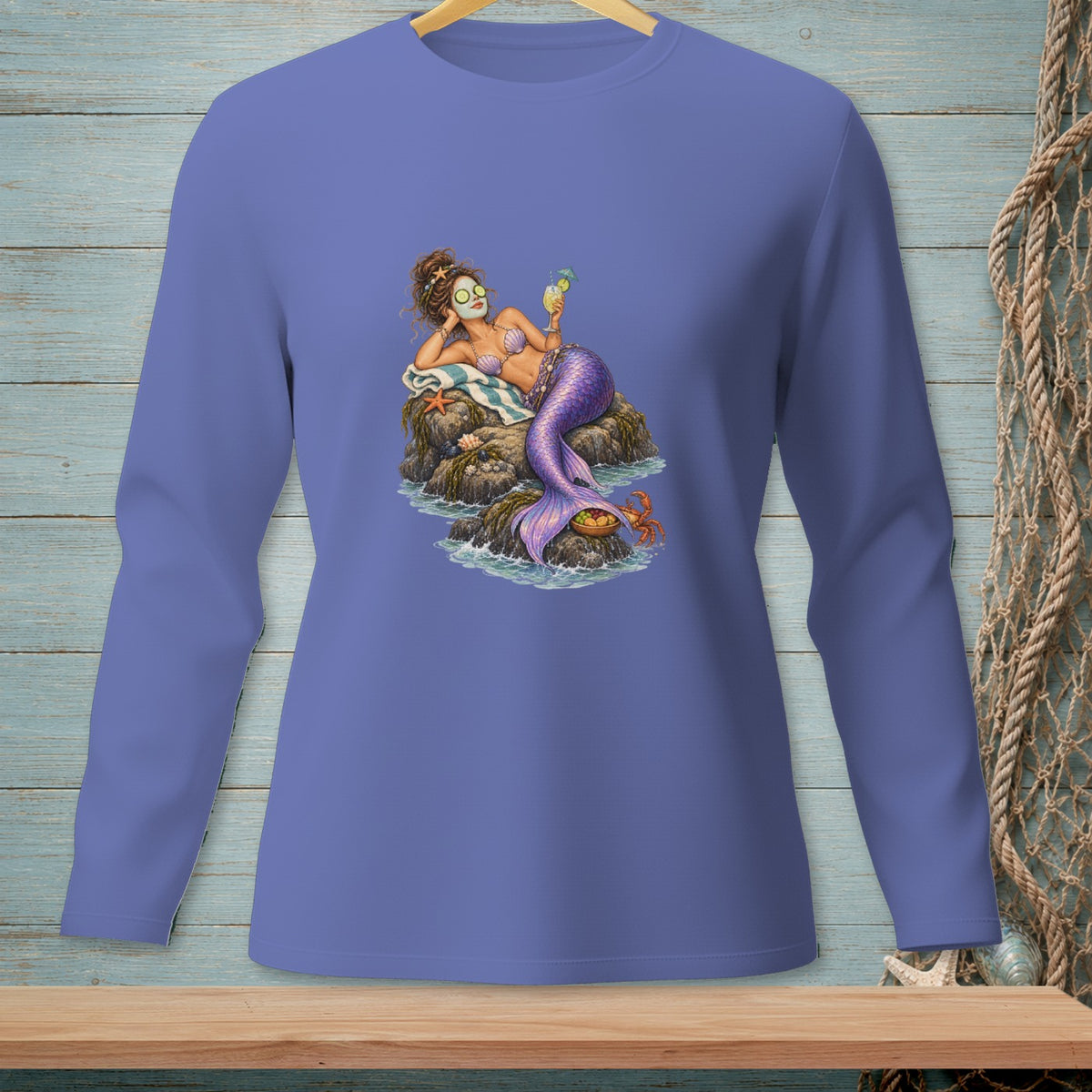 Mermaid relaxing on rocks with a drink and face mask, crab nearby.