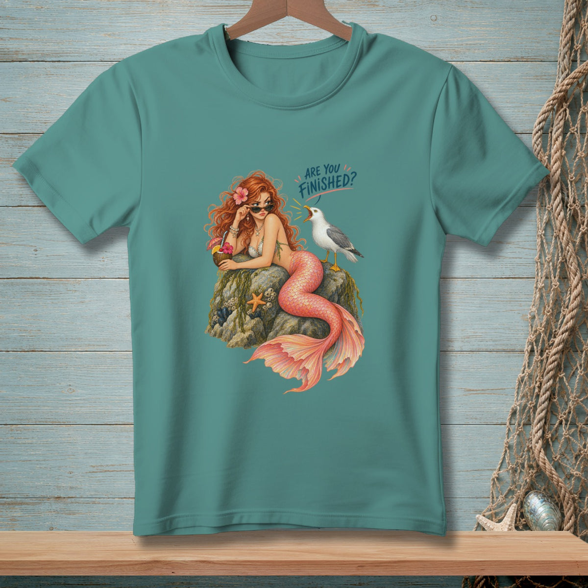 Teal t-shirt with mermaid and seagull graphic saying "ARE YOU FINISHED?".