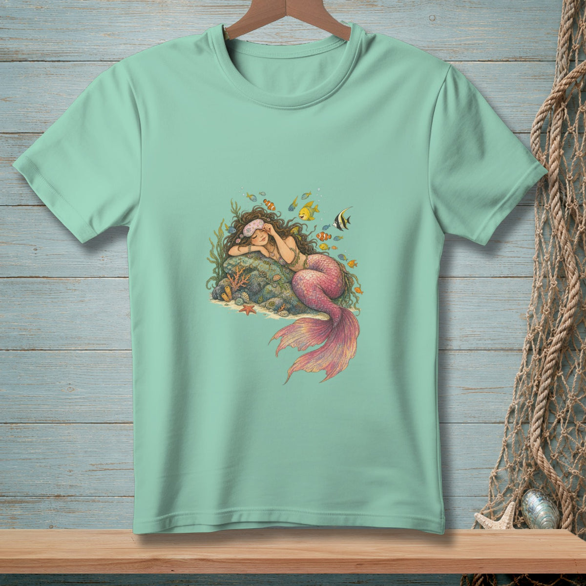 Light mint t-shirt with sleeping mermaid, fish, and coral graphic.