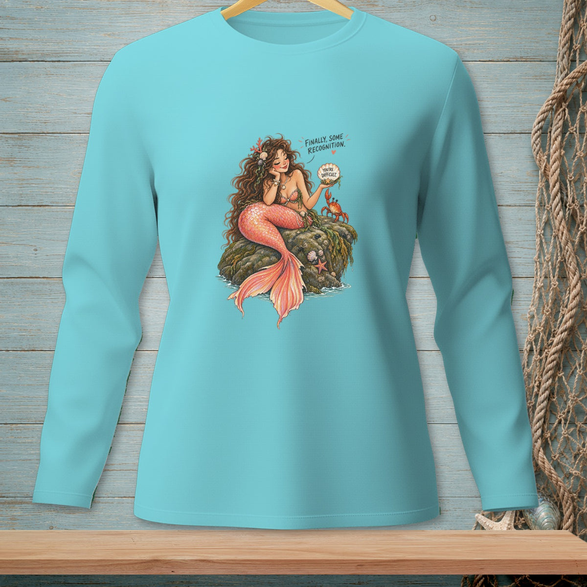 Teal long sleeve shirt with a mermaid illustration and speech bubbles.