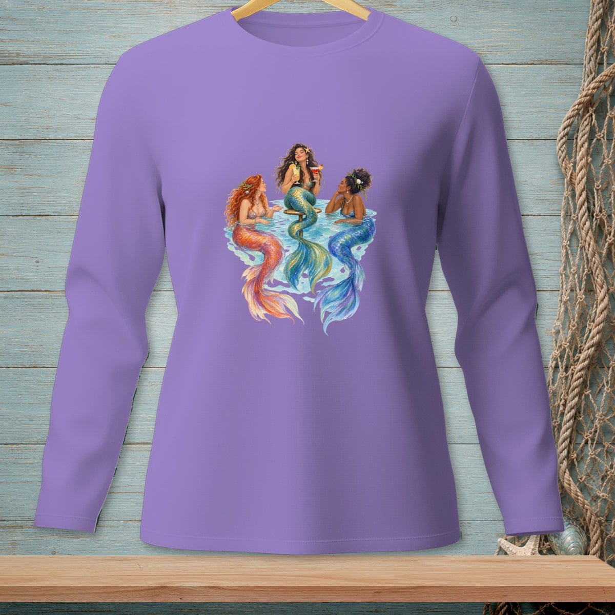 Three mermaids with colorful tails gather in the water, one holding a drink.