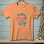 Peach t-shirt with "Resting Beach Face" text and mermaid tail graphic.