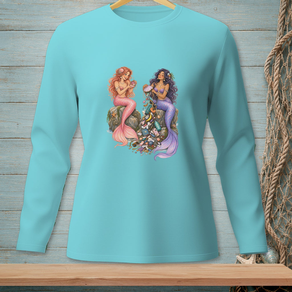 Two mermaids sit on rocks, one with pink tail, the other with purple, surrounded by trash.