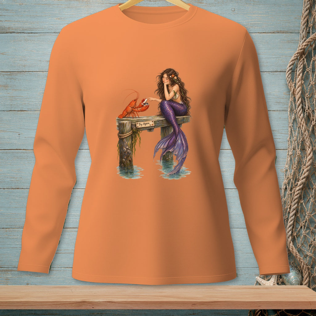 Orange long-sleeve shirt with a mermaid and lobster on a pier graphic.