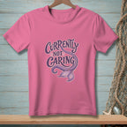 Pink t-shirt with "Currently Not Caring" text and a purple mermaid tail graphic.