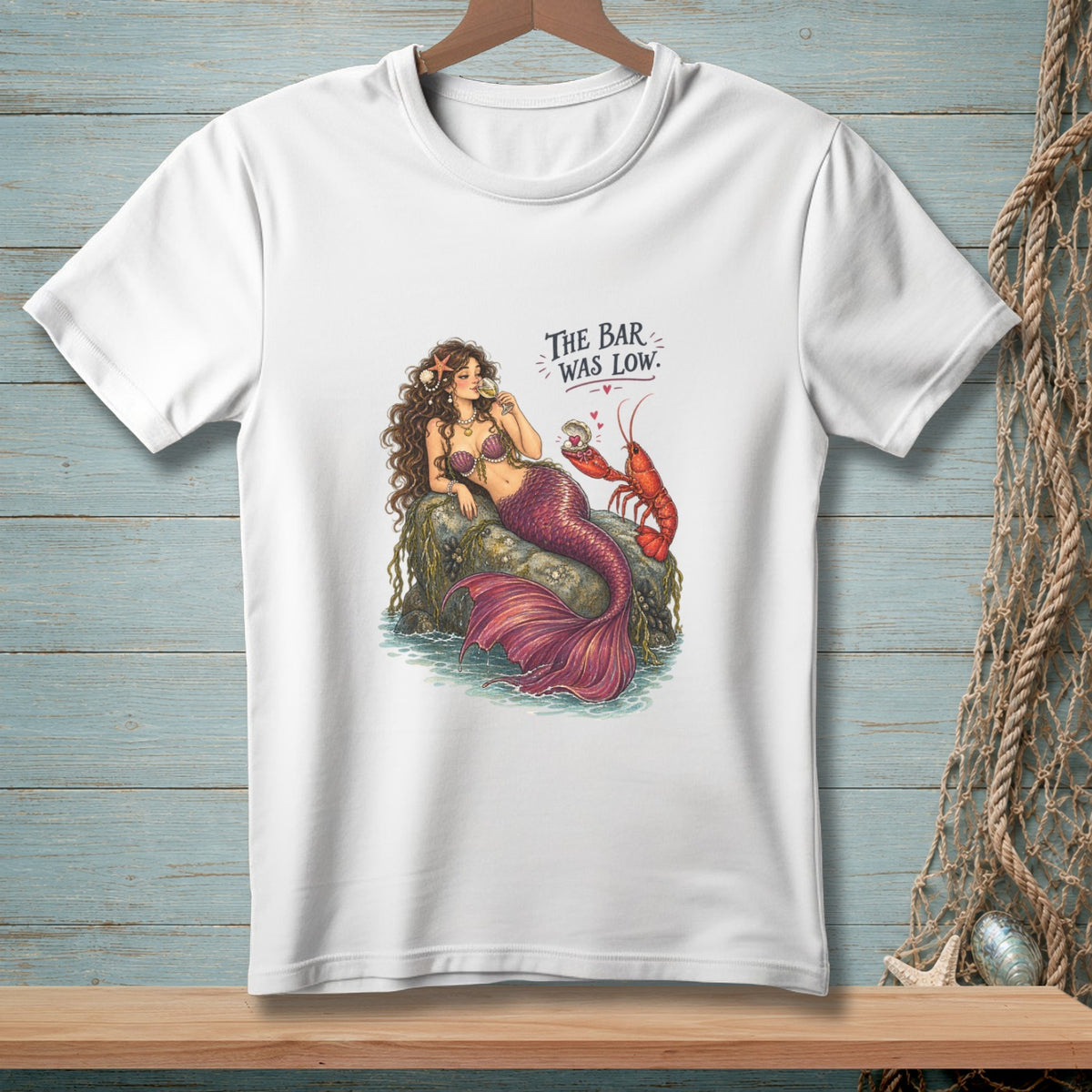 Mermaid with lobster and text "THE BAR WAS LOW." on a white t-shirt.