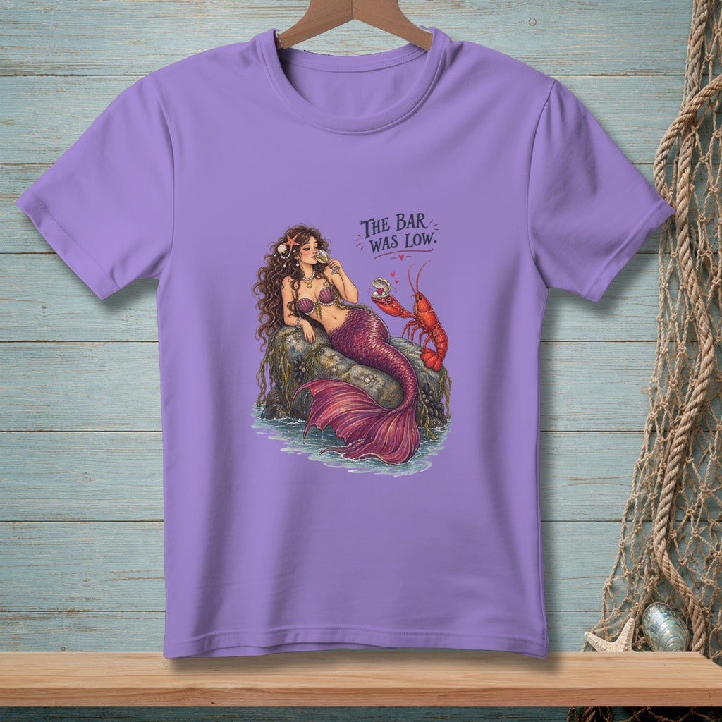 Purple t-shirt with a mermaid and lobster, text reads "The bar was low."