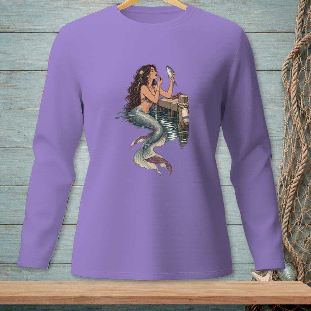 Mermaid applying makeup to a fish on a dock.