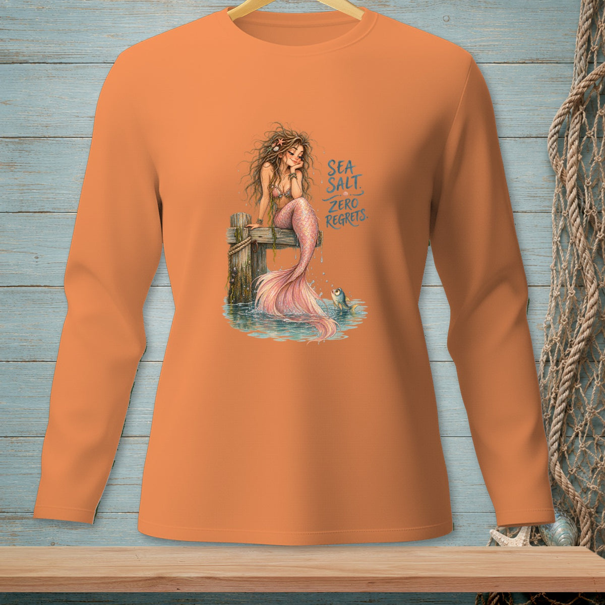 Orange long-sleeve shirt with a mermaid and fish graphic and text.