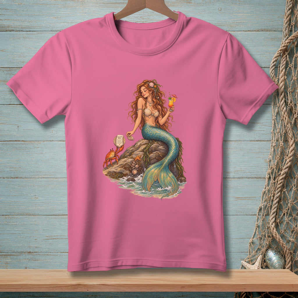 Mermaid with crab and cocktail sitting on a rock by the sea.