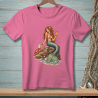 Mermaid with crab and cocktail sitting on a rock by the sea.