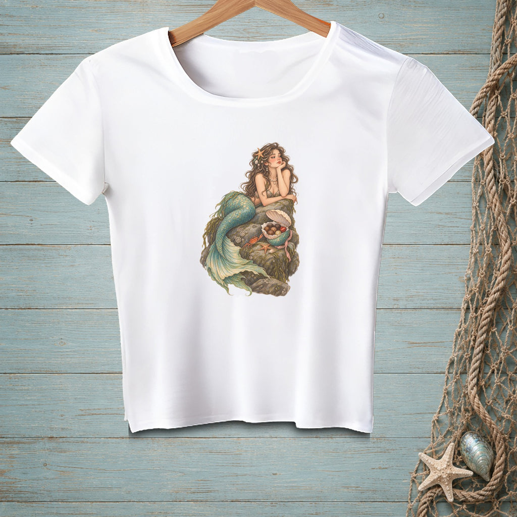 White t-shirt featuring a detailed illustration of a mermaid lounging on rocks.