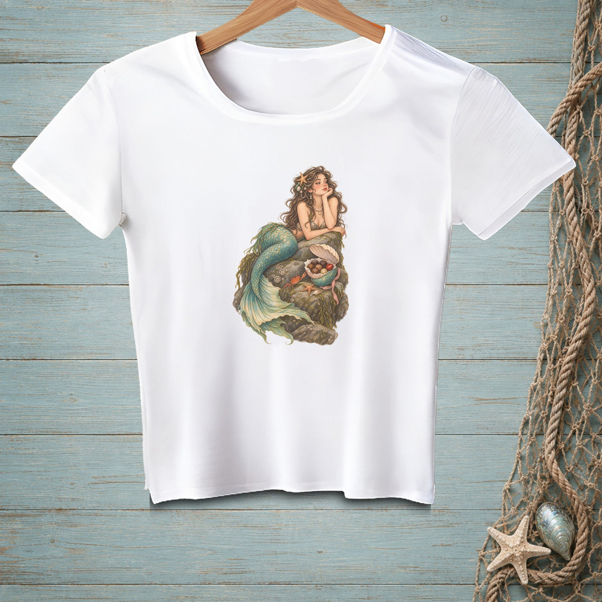 White t-shirt featuring a detailed illustration of a mermaid lounging on rocks.