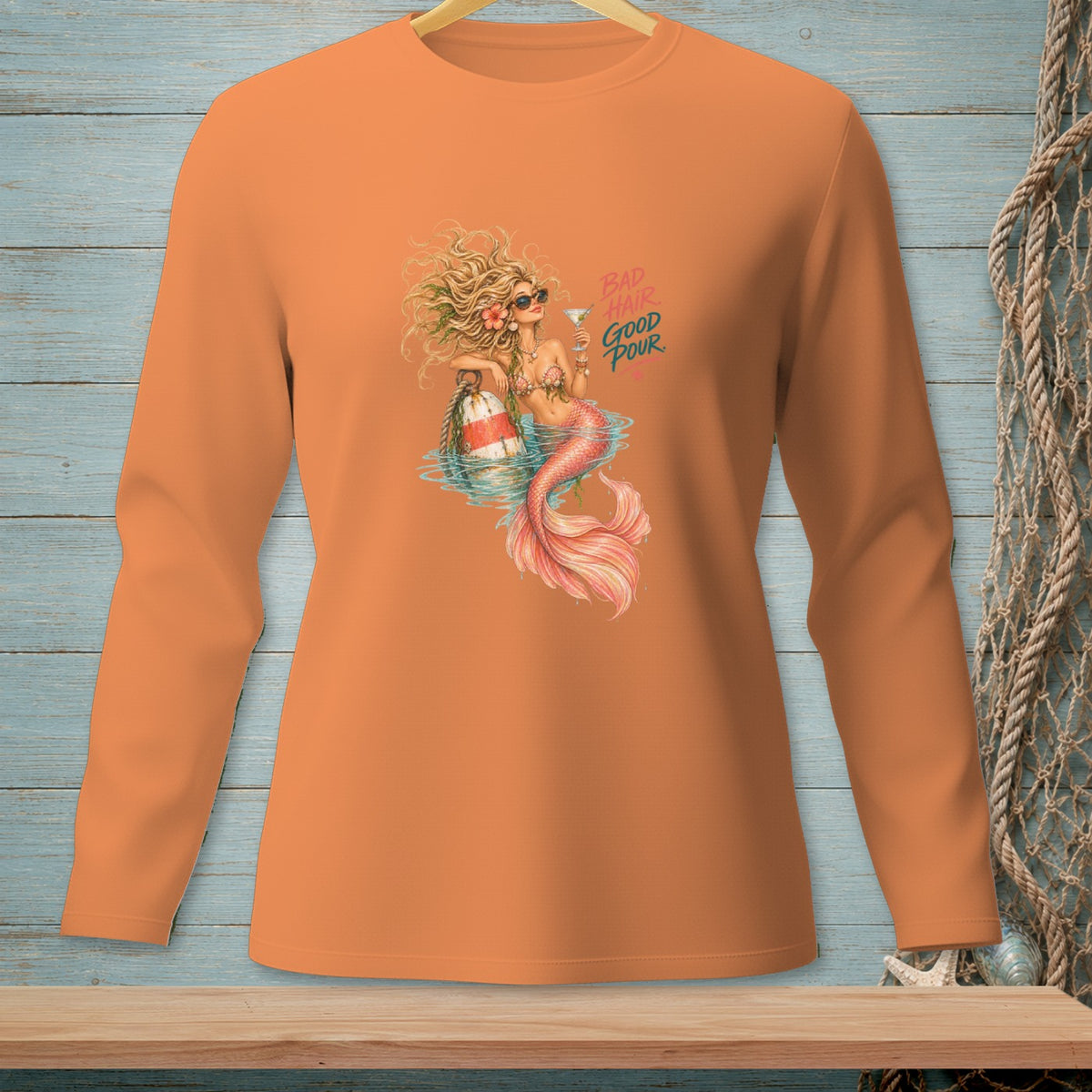 Orange long-sleeve shirt with mermaid graphic and text "Bad Hair Good Pour".