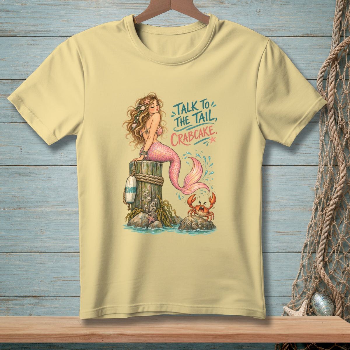 Yellow t-shirt with mermaid, crab, and text "TALK TO THE TAIL, CRABCAKE."