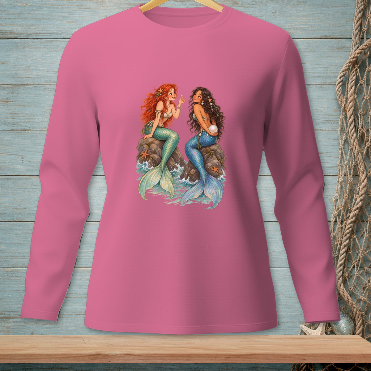 Two mermaids sitting on rocks with a pearl and starfish.