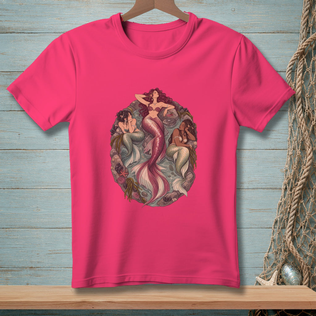 Three mermaids with fishtails resting on rocks and seaweed in an oval frame.