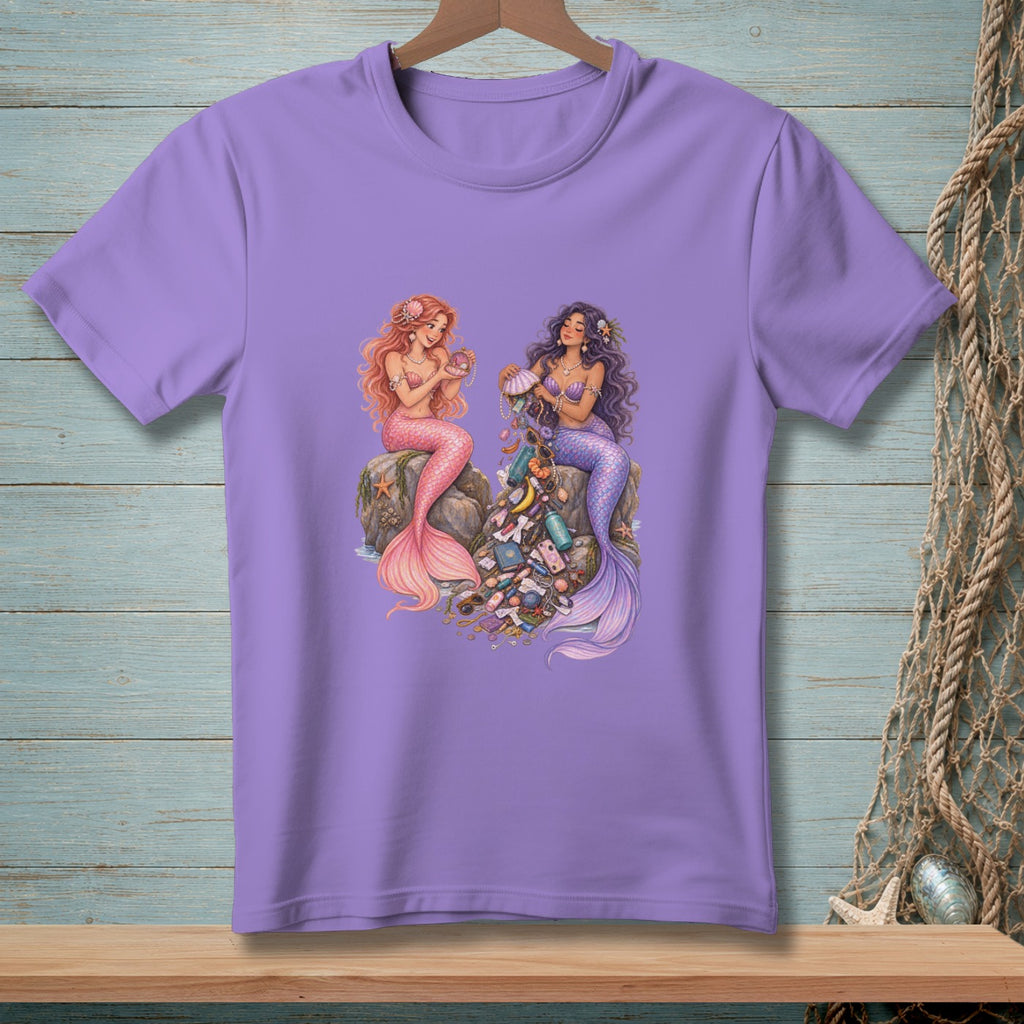 Two mermaids sit on rocks, surrounded by a collection of found objects and jewelry.