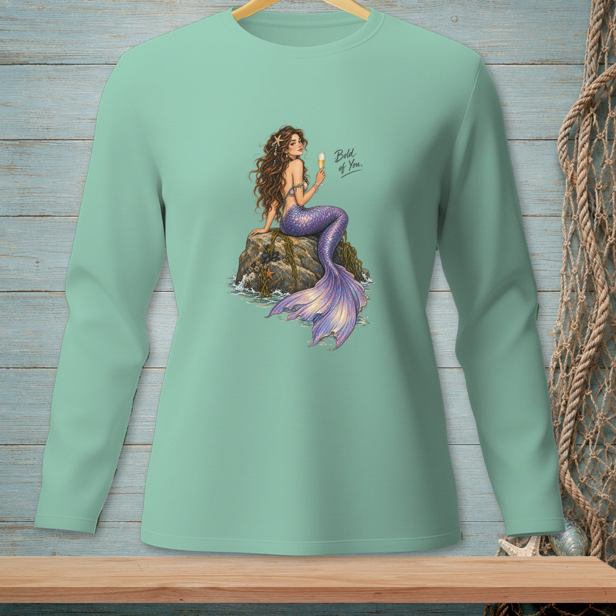 Green long-sleeve shirt with mermaid art and text "Bold of You."