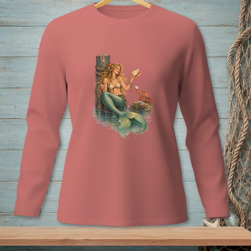 Long-sleeve shirt with a print of a mermaid holding a seashell by a wooden post and a crab.