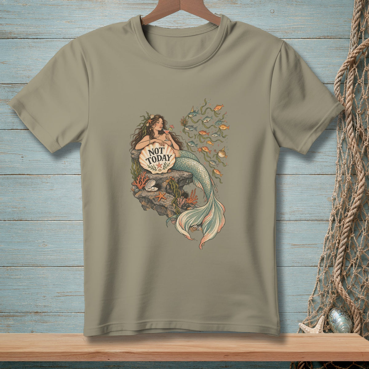 T-shirt graphic of mermaid sitting on a rock with a seashell that reads "NOT TODAY".