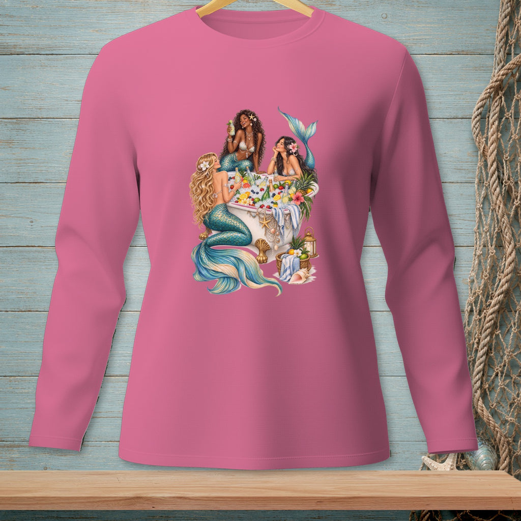 Three mermaids relax in a bathtub filled with fruit and flowers.