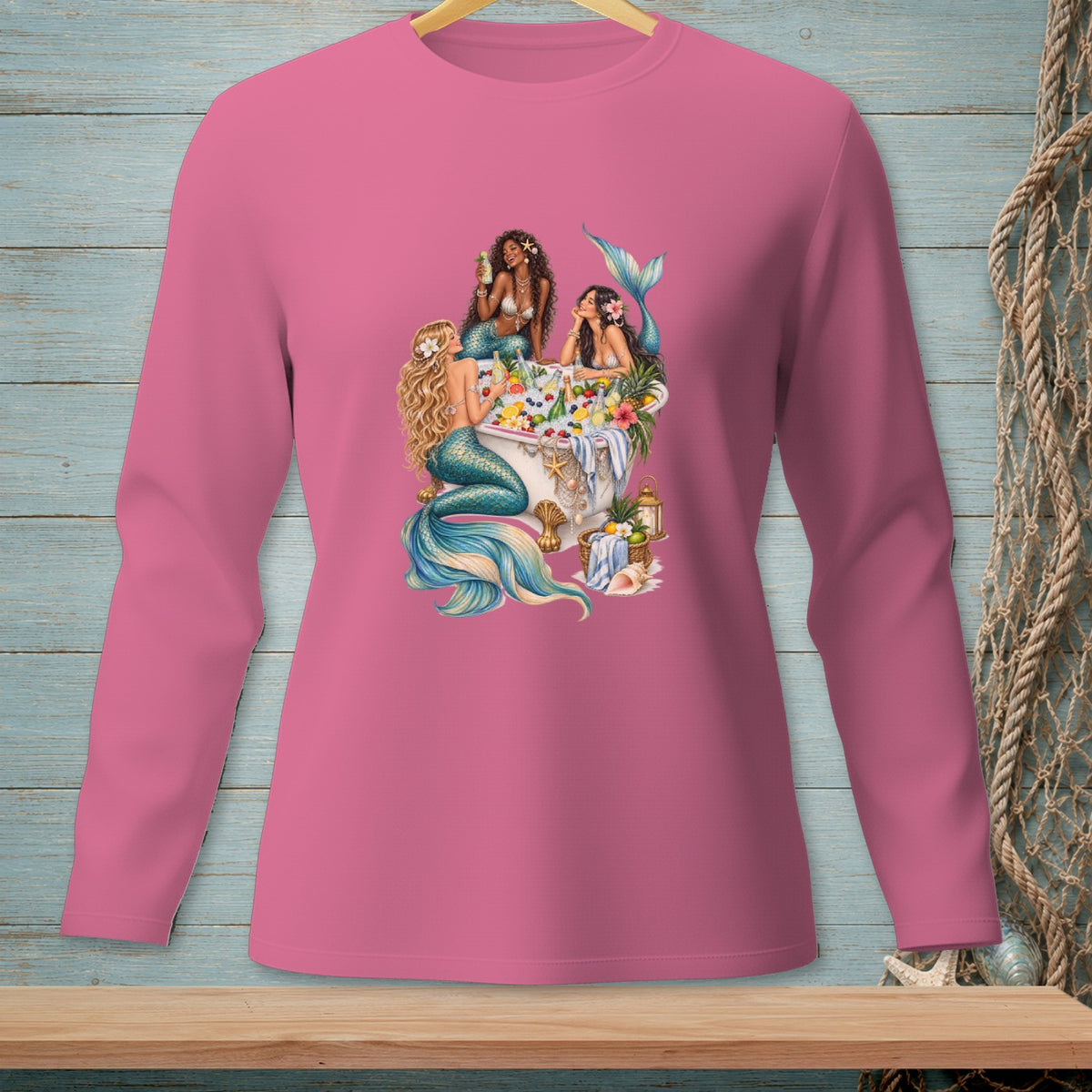 Three mermaids relax in a bathtub filled with fruit and flowers.