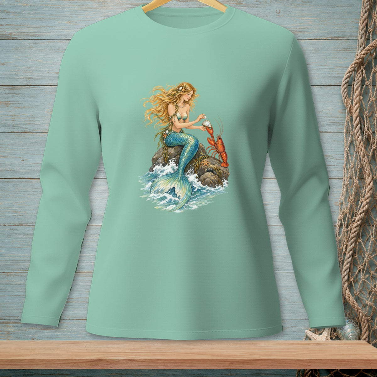 Mermaid with long blonde hair sits on a rock with a lobster and pearl.