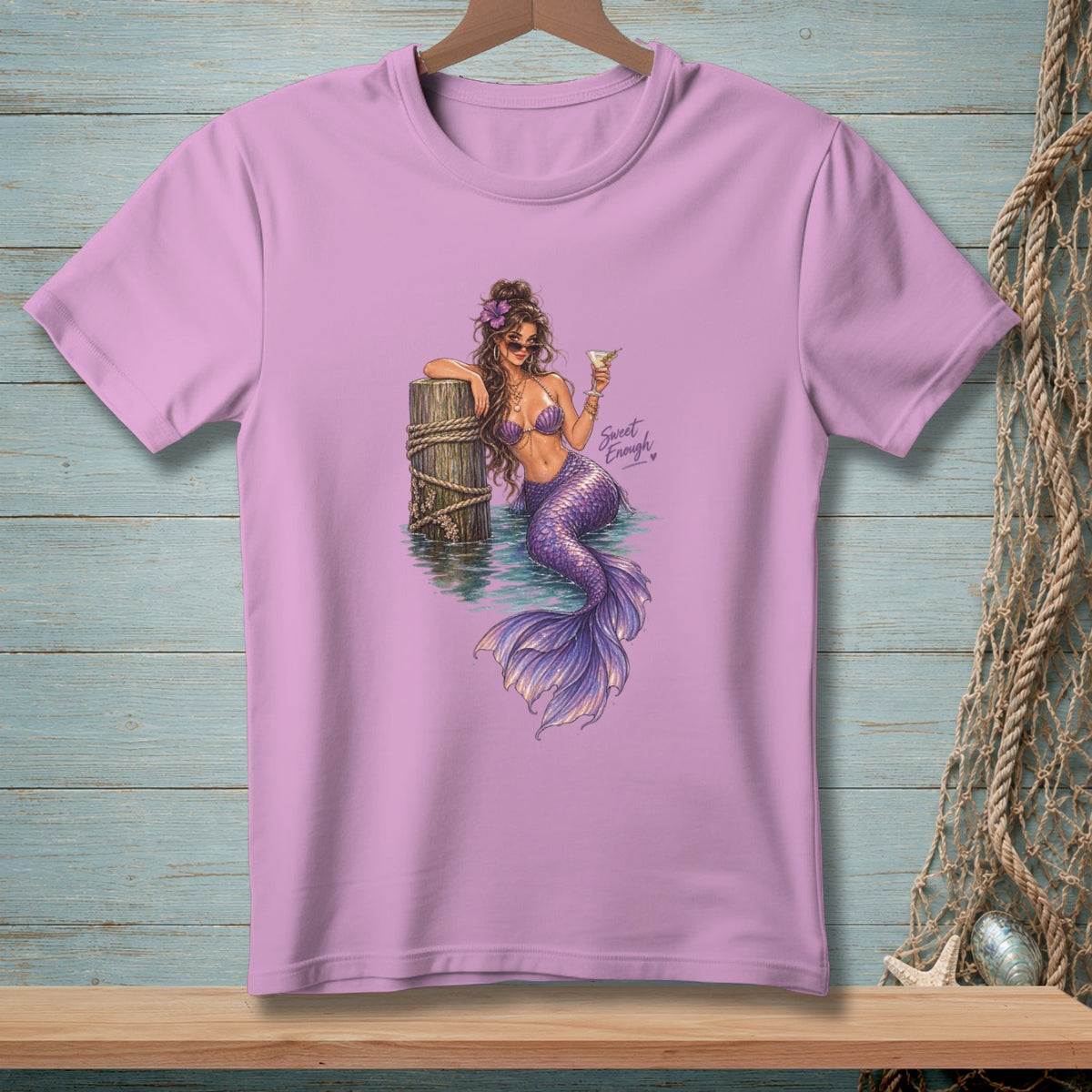 Lilac t-shirt featuring a mermaid with a purple tail holding a drink.