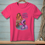 Pink t-shirt with mermaid on dock, text "Salty, Tangled & Unbothered."