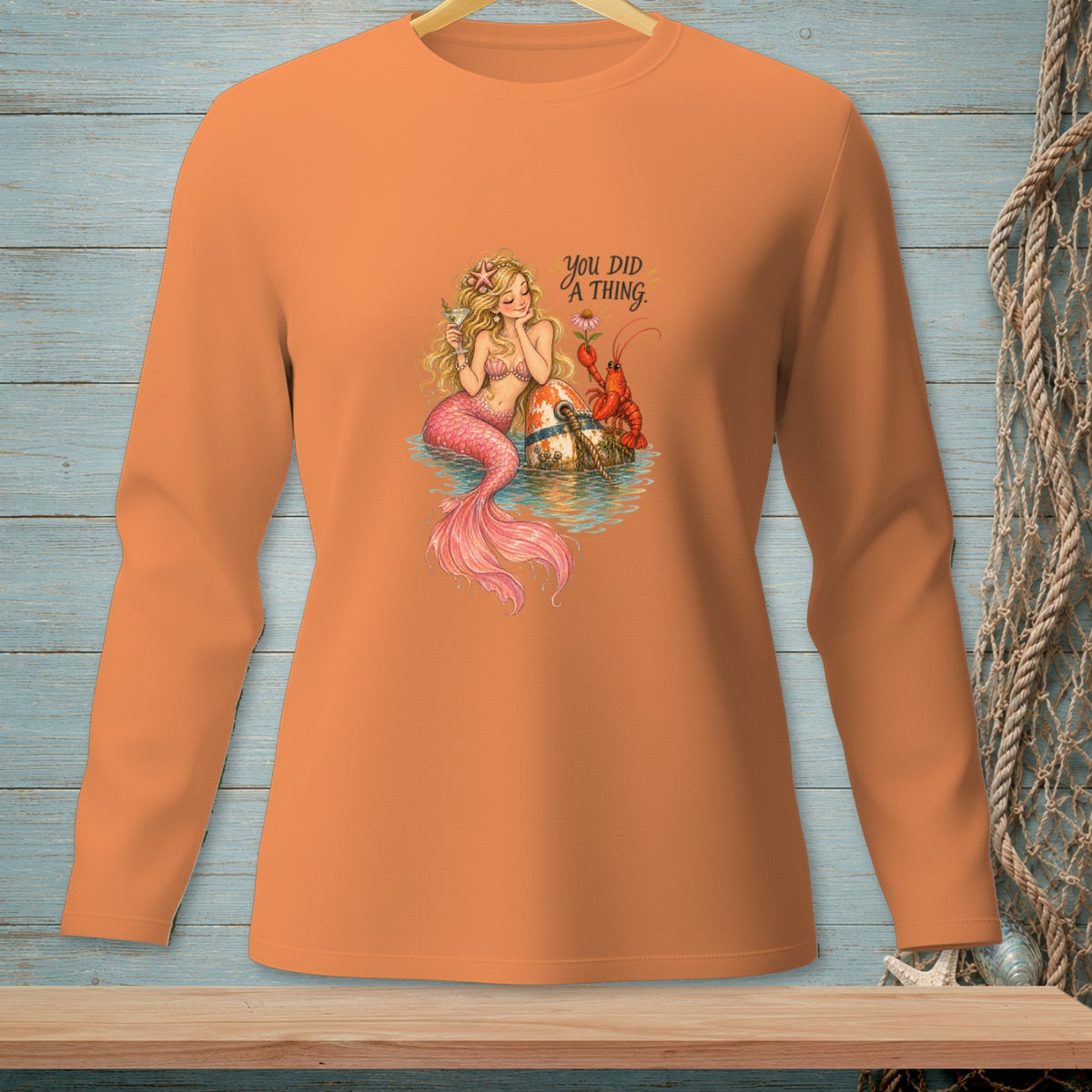 Orange long-sleeve shirt featuring a mermaid, lobster, buoy, and text: "YOU DID A THING."