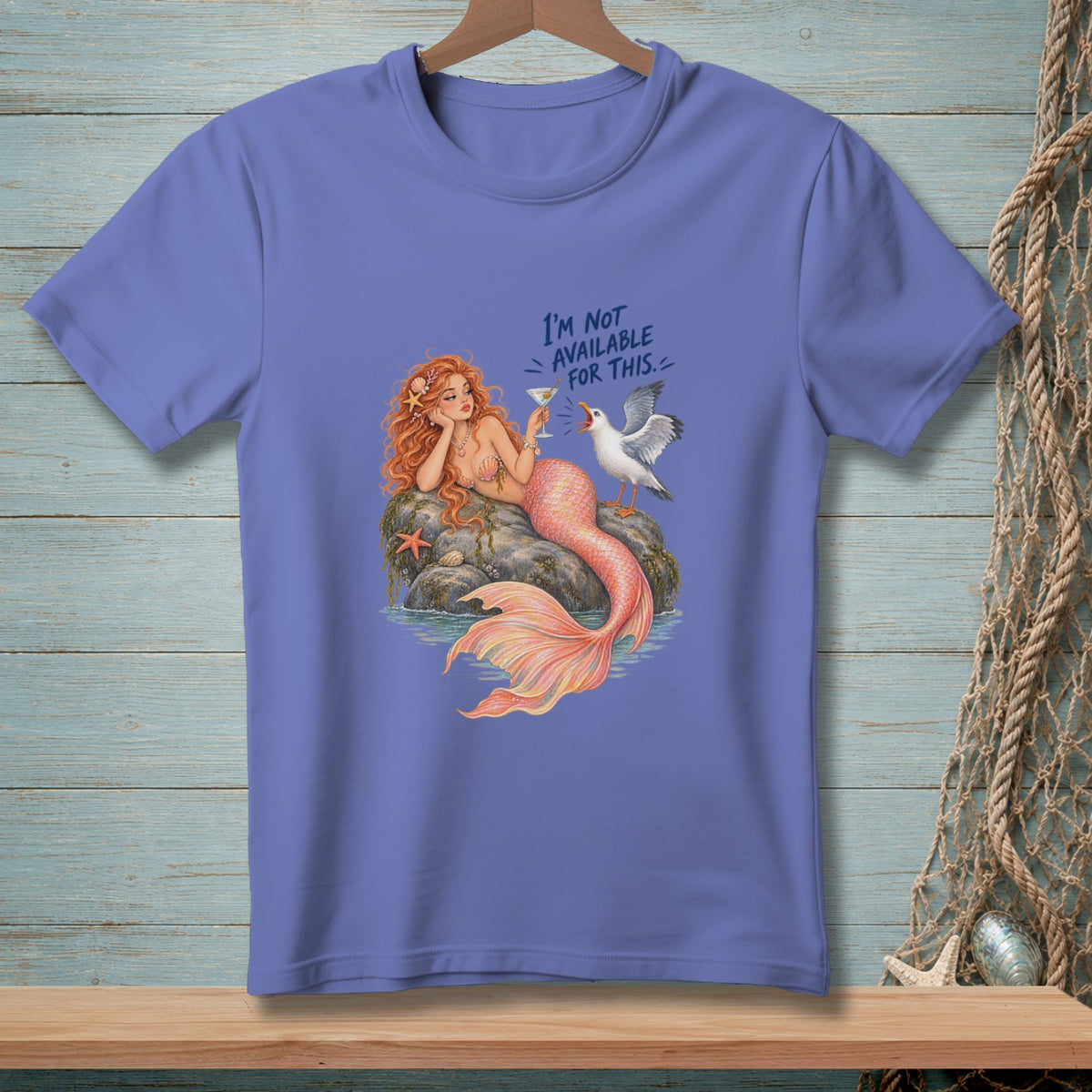 Mermaid with red hair and coral tail, holding a drink, with a seagull and text.