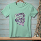 Mint t-shirt with purple text "Currently Not Caring" and a mermaid tail.