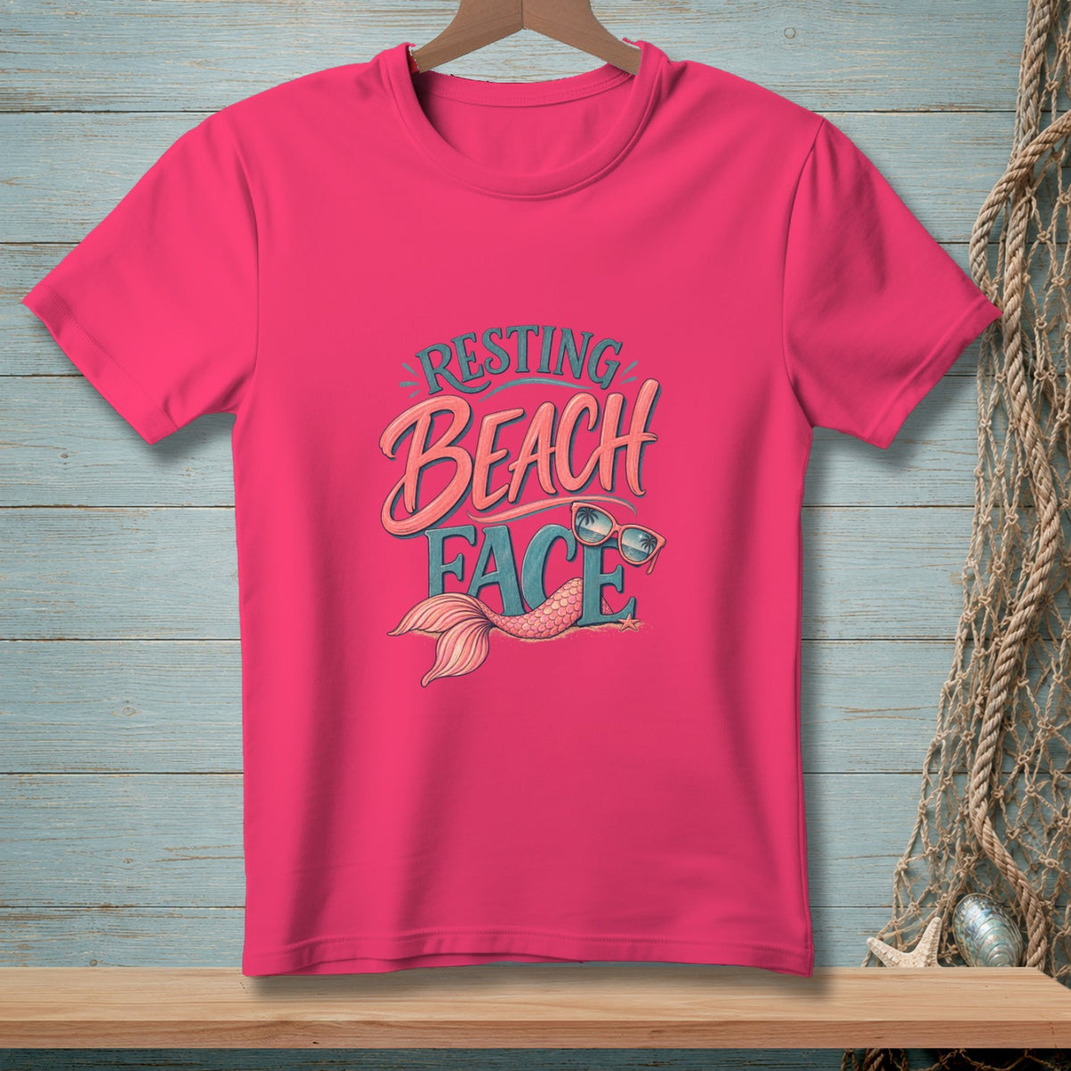 Pink t-shirt with "Resting Beach Face" text and mermaid tail graphic.