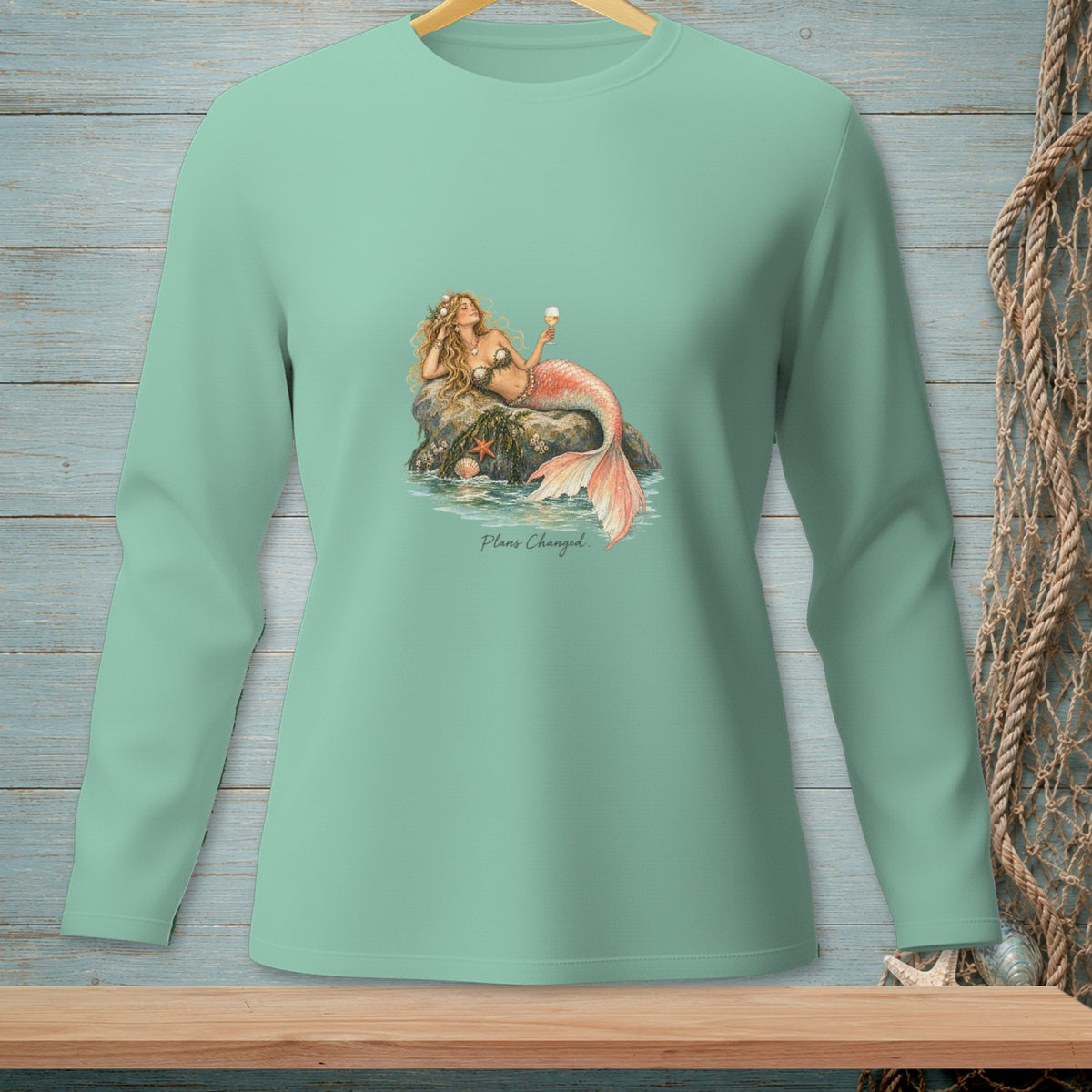 Mint long-sleeve shirt with a mermaid lounging on a rock, holding a drink, and text "Plans Changed."