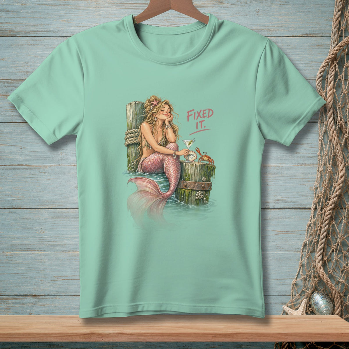 Mermaid with pink tail and crab sits by a post, text "Fixed It."