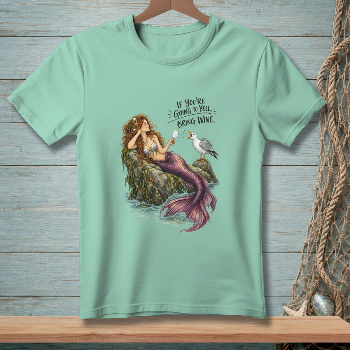 Mint green t-shirt with mermaid, seagull, and text "If you're going to yell, bring wine."