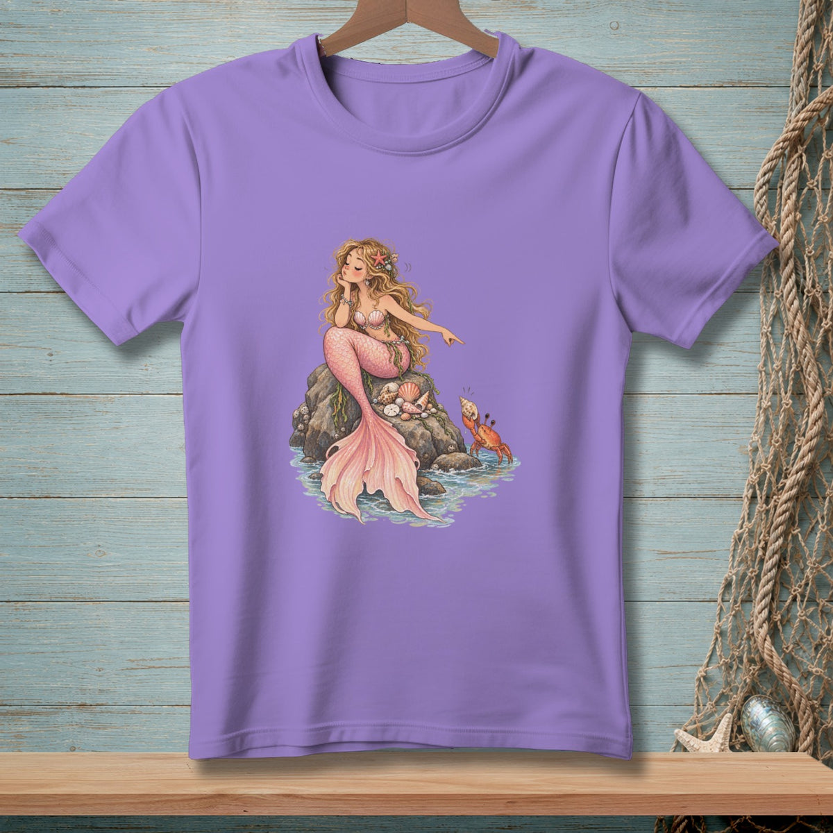 Purple t-shirt with illustration of a mermaid sitting on a rock with a crab nearby.
