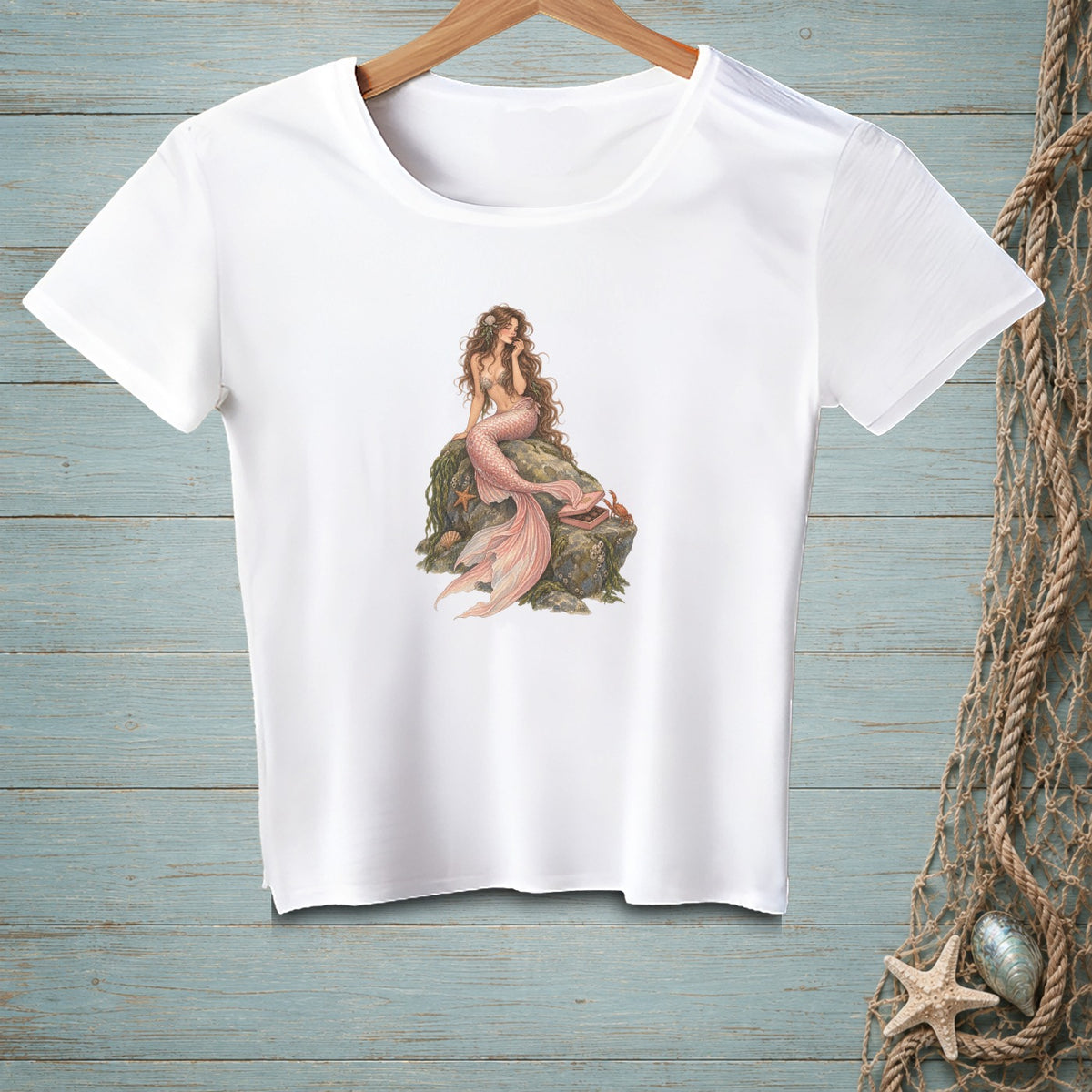 White t-shirt with a mermaid sitting on a rock, detailed illustration.