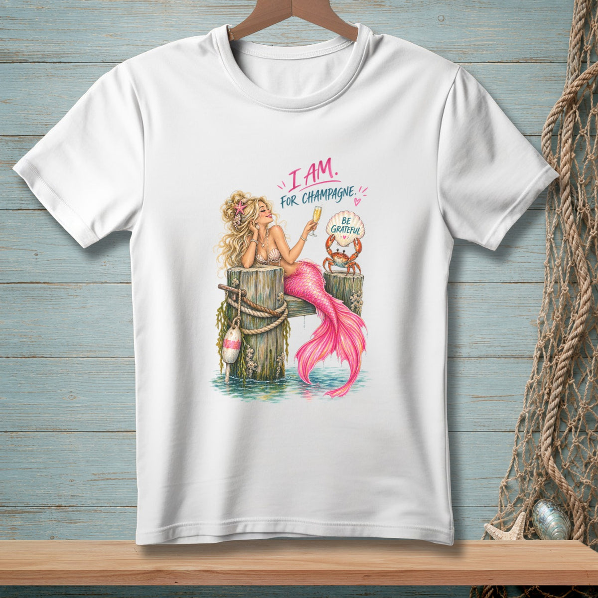 Mermaid holding champagne with crab saying "Be Grateful" on a dock.