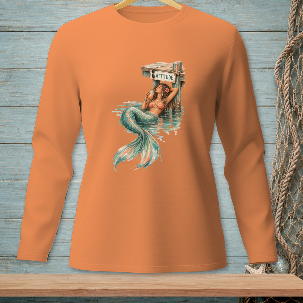 Orange long-sleeve shirt with a graphic of a mermaid relaxing on a dock with "ATTITUDE" sign.