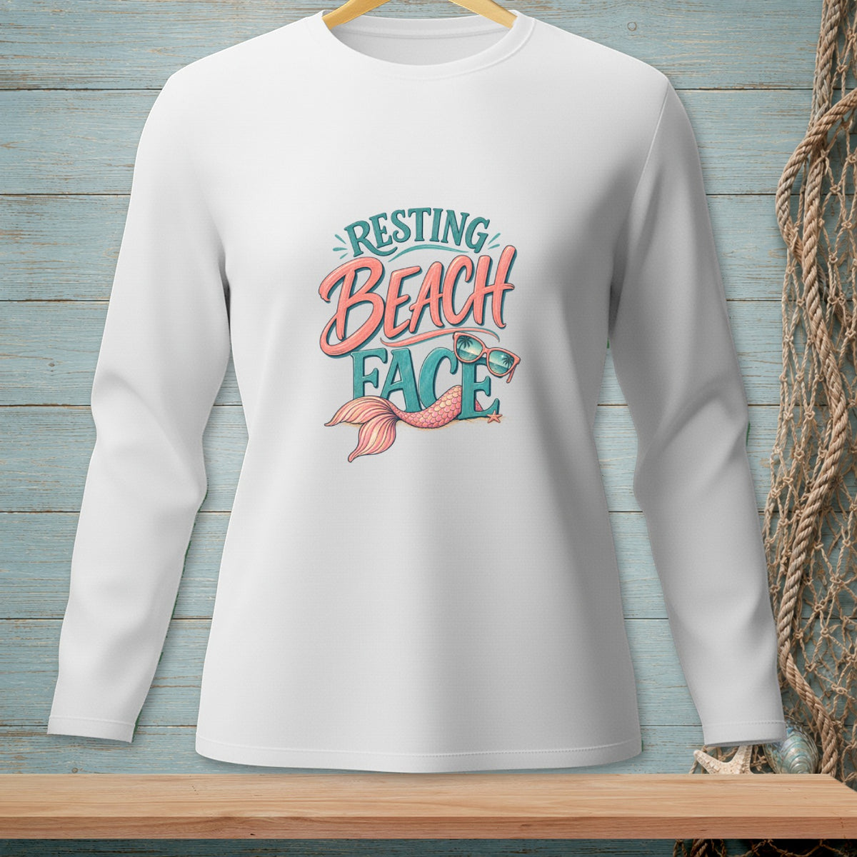 White long-sleeved shirt with "Resting Beach Face" graphic and mermaid tail.