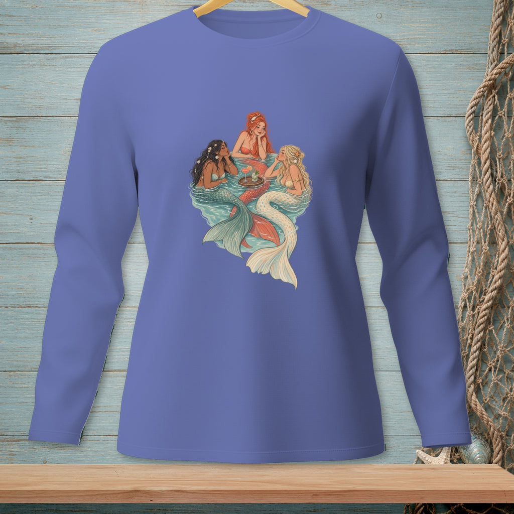 Three mermaids with colorful tails swim and hold drinks in water.